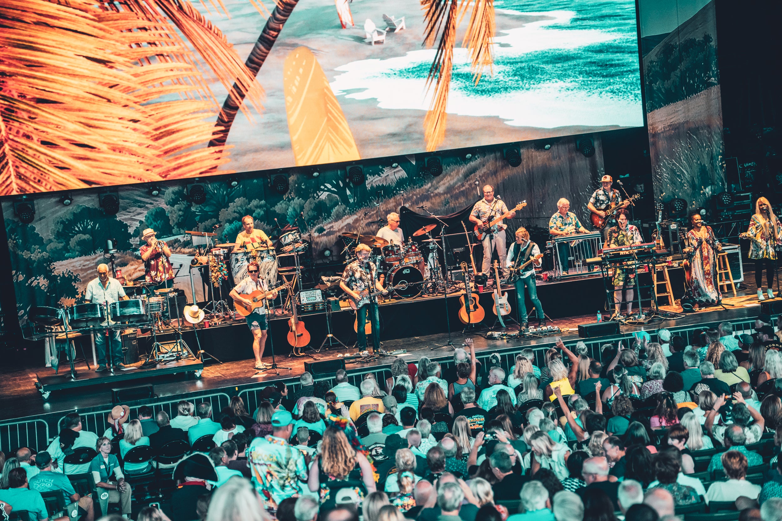 Live concert with The Coral Reefer Band on stage and audience in a large venue